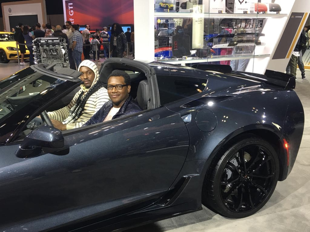 A Car enthusiast sitting in a corvette c7 grand sport at the jacob javits center new york auto show.