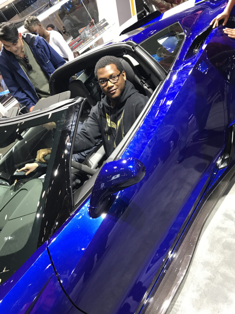 A Car enthusiast sitting in a corvette c7 z06 at the jacob javits center new york auto show.